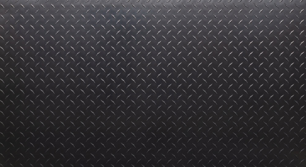Dark metal surface with a repeating diamond plate pattern, featuring raised, crisscrossing lines that create a textured, industrial look—ideal for luxury vehicle storage in Nassau & Suffolk County, NY.